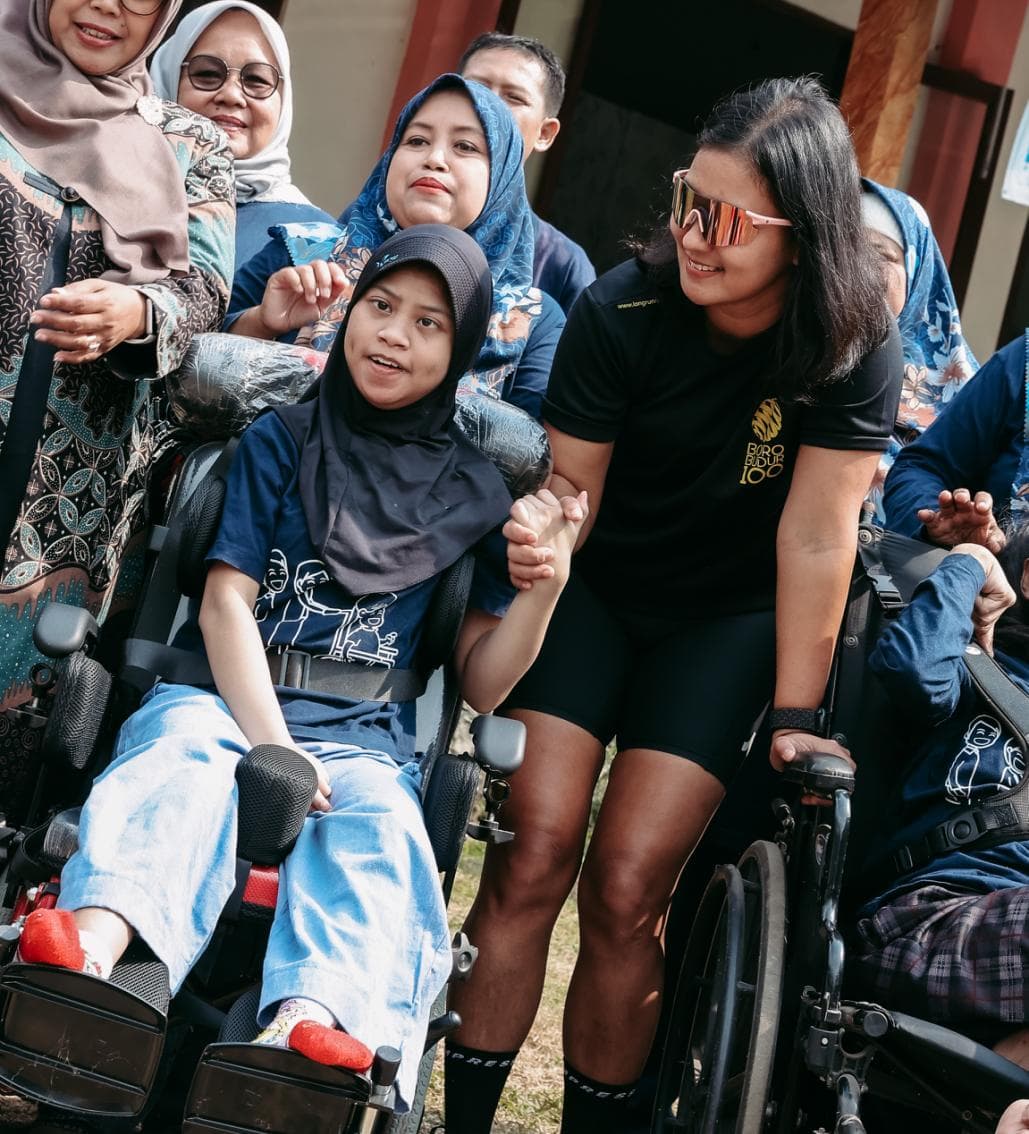 Pelari BOROBUDUR100 bergandengan tangan dengan anak di kursi roda